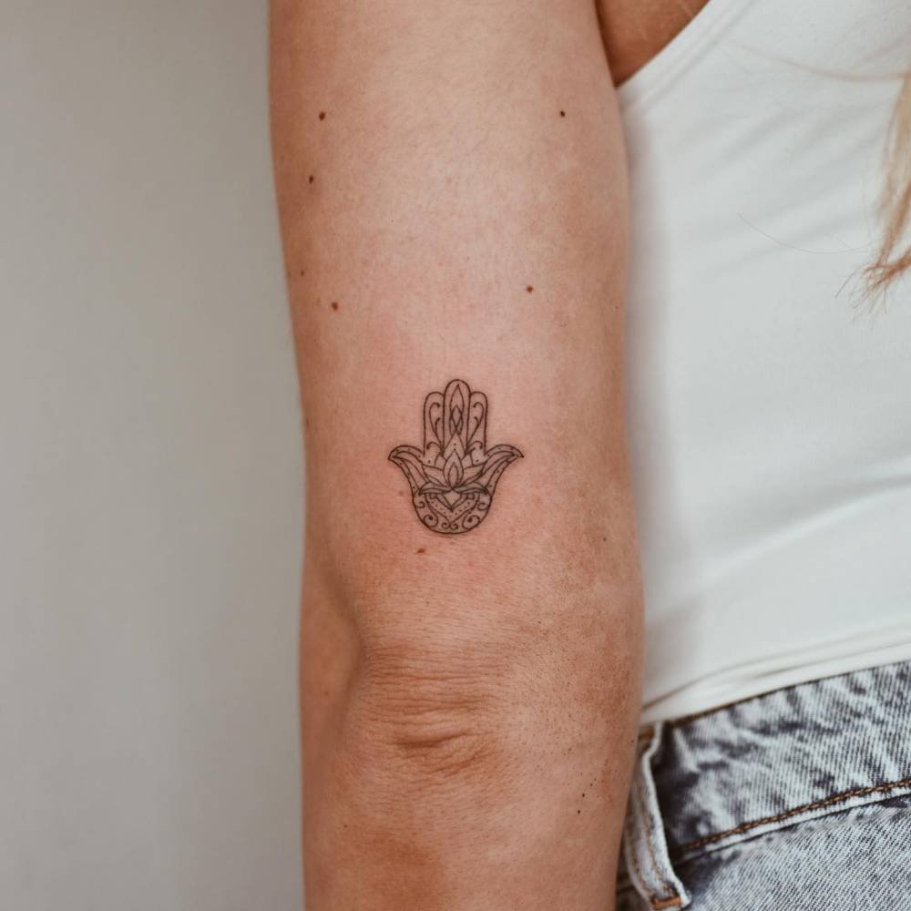 Minimalist hamsa hand on the arm