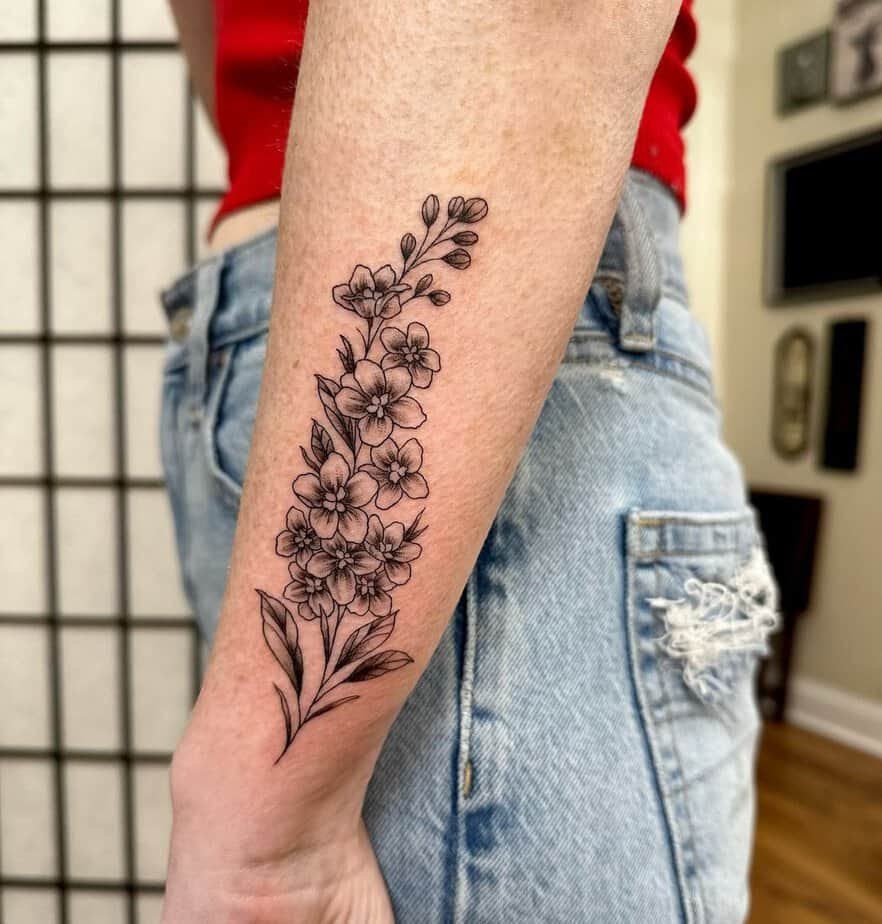 Elegant forearm larkspur tattoo