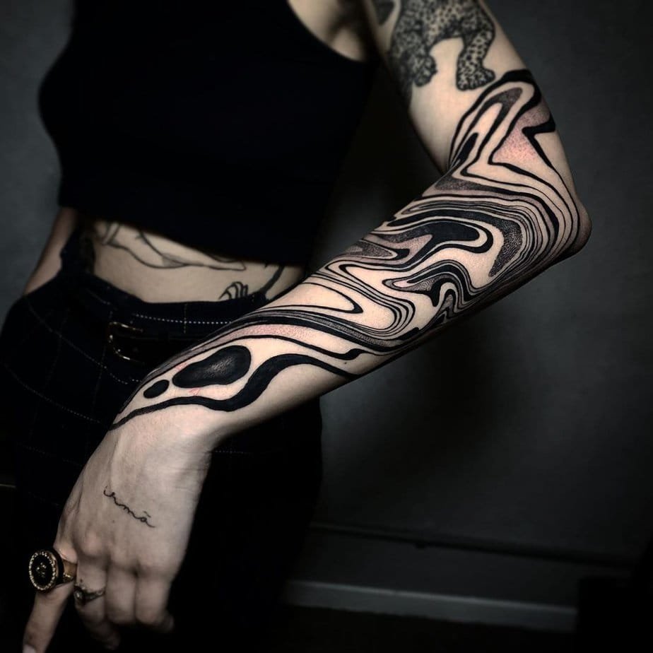 Dark, bold suminagashi swirls wrapping the forearm