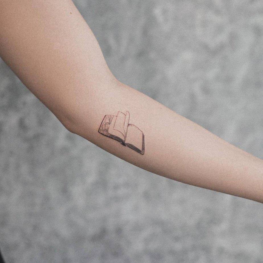 Minimalist open book tattoo