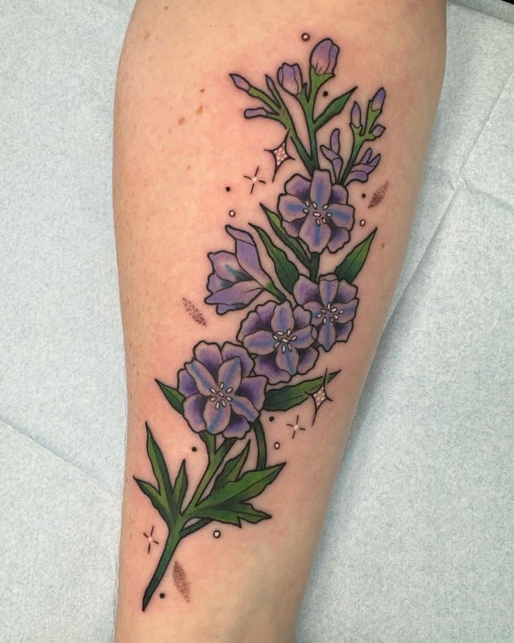 Bold purple larkspur tattoo with sparkle details