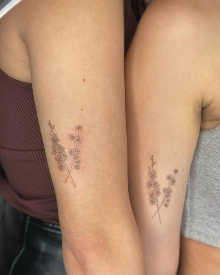 Matching minimalist larkspur tattoos