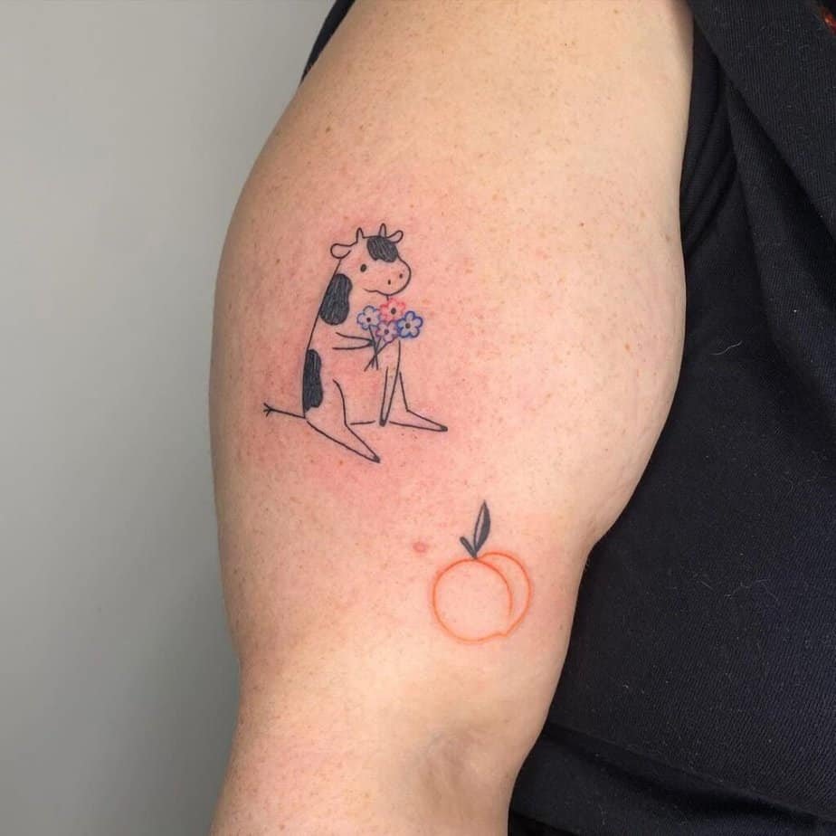 11. A tattoo of a cow holding colorful flowers