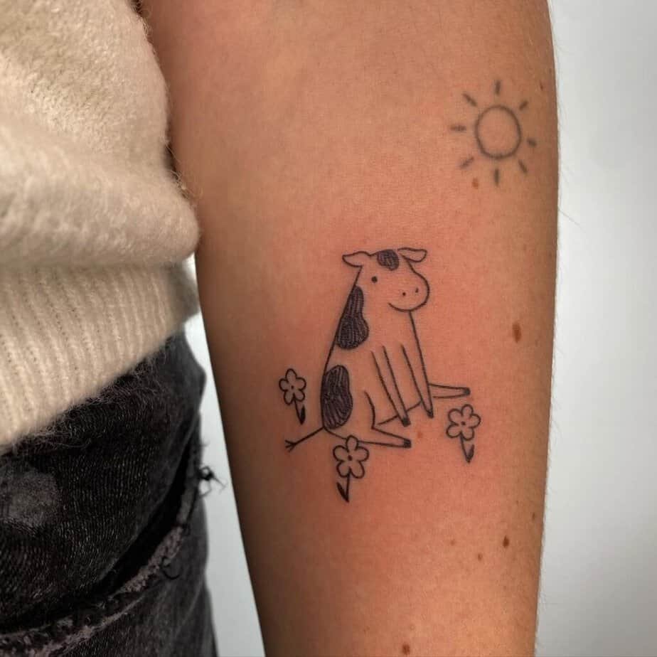 8. A tattoo of a cow surrounded by flowers
