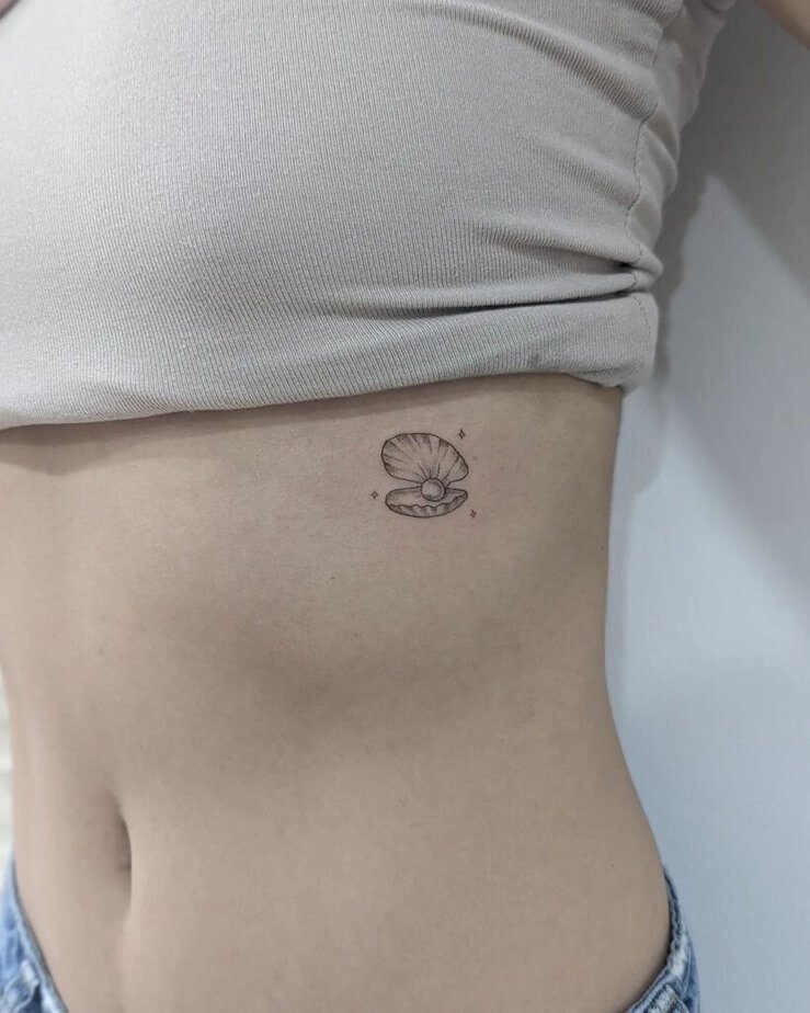 20. A small seashell pearl tattoo on the ribcage