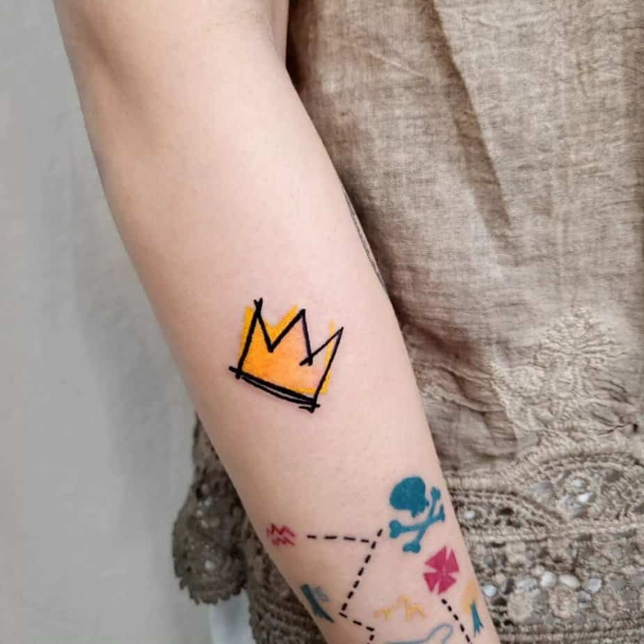 12. A Basquiat crown tattoo on the upper arm