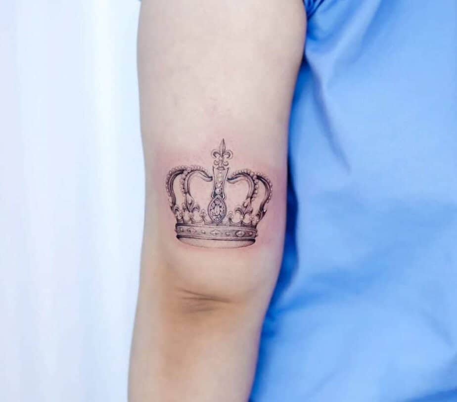 6. A delicate crown tattoo on the back of the arm