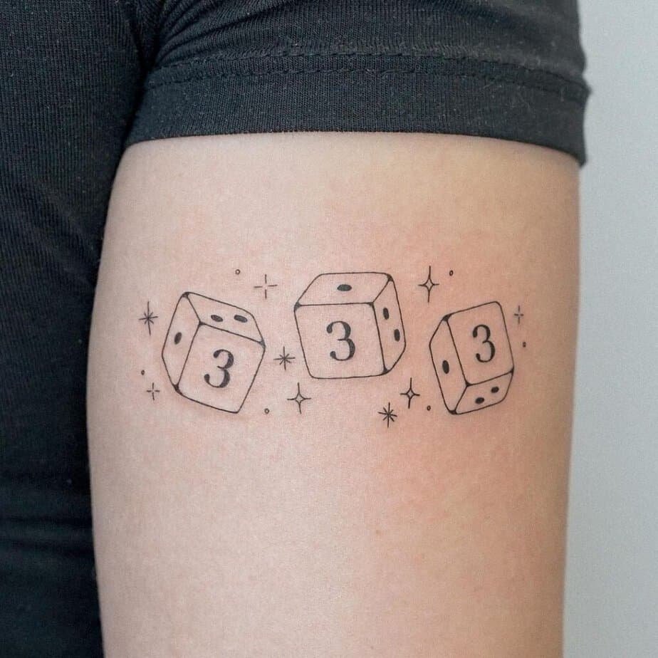 23. An angel number dice tattoo on the upper arm