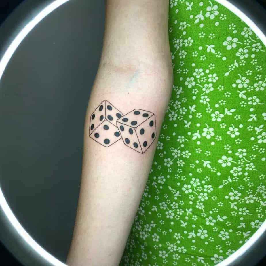 24. A big and bold dice tattoo on the forearm
