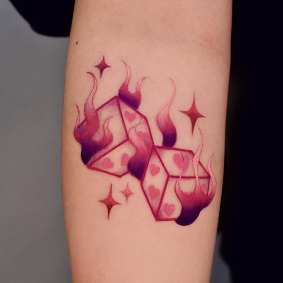 19. Pink dice tattoo on the forearm