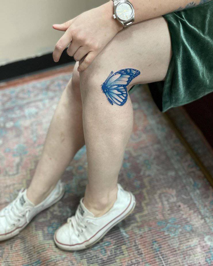 Blue butterfly knee tattoo