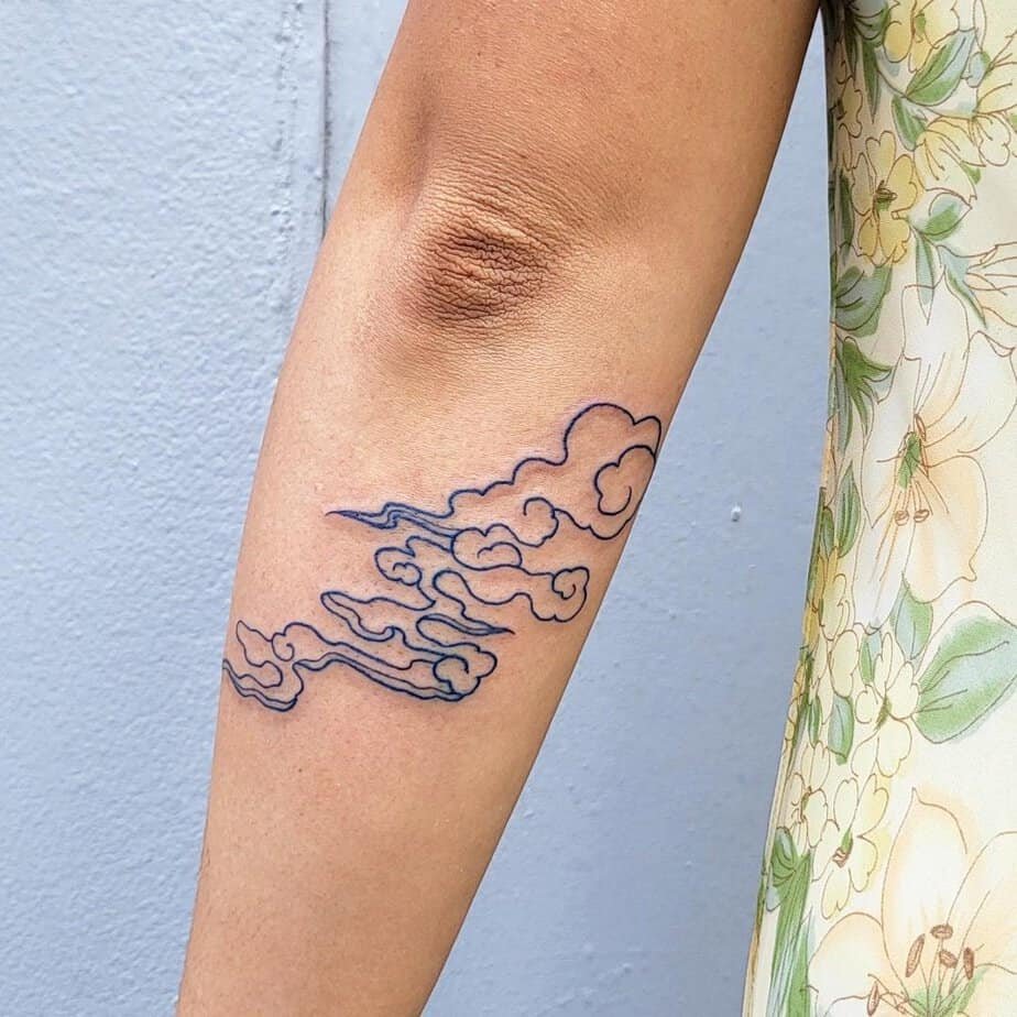 Blue clouds forearm tattoo