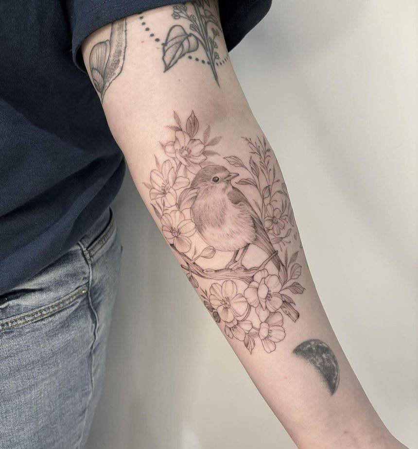 Delicate robin tattoo on the forearm