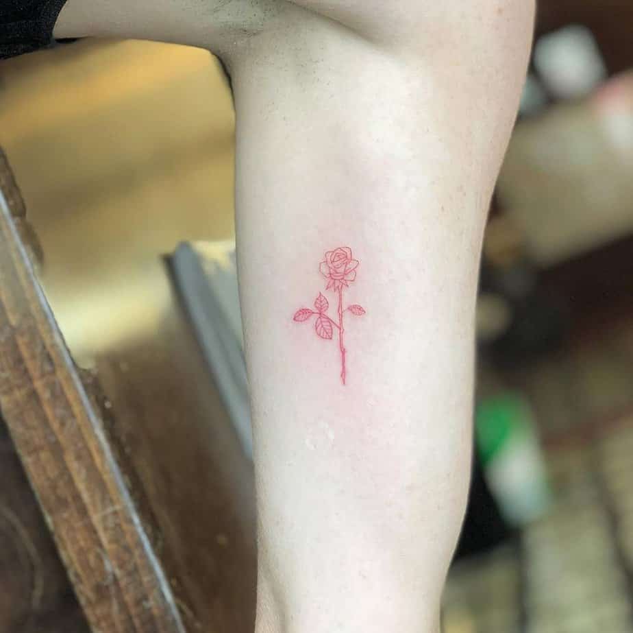 Red ink tiny rose tattoo